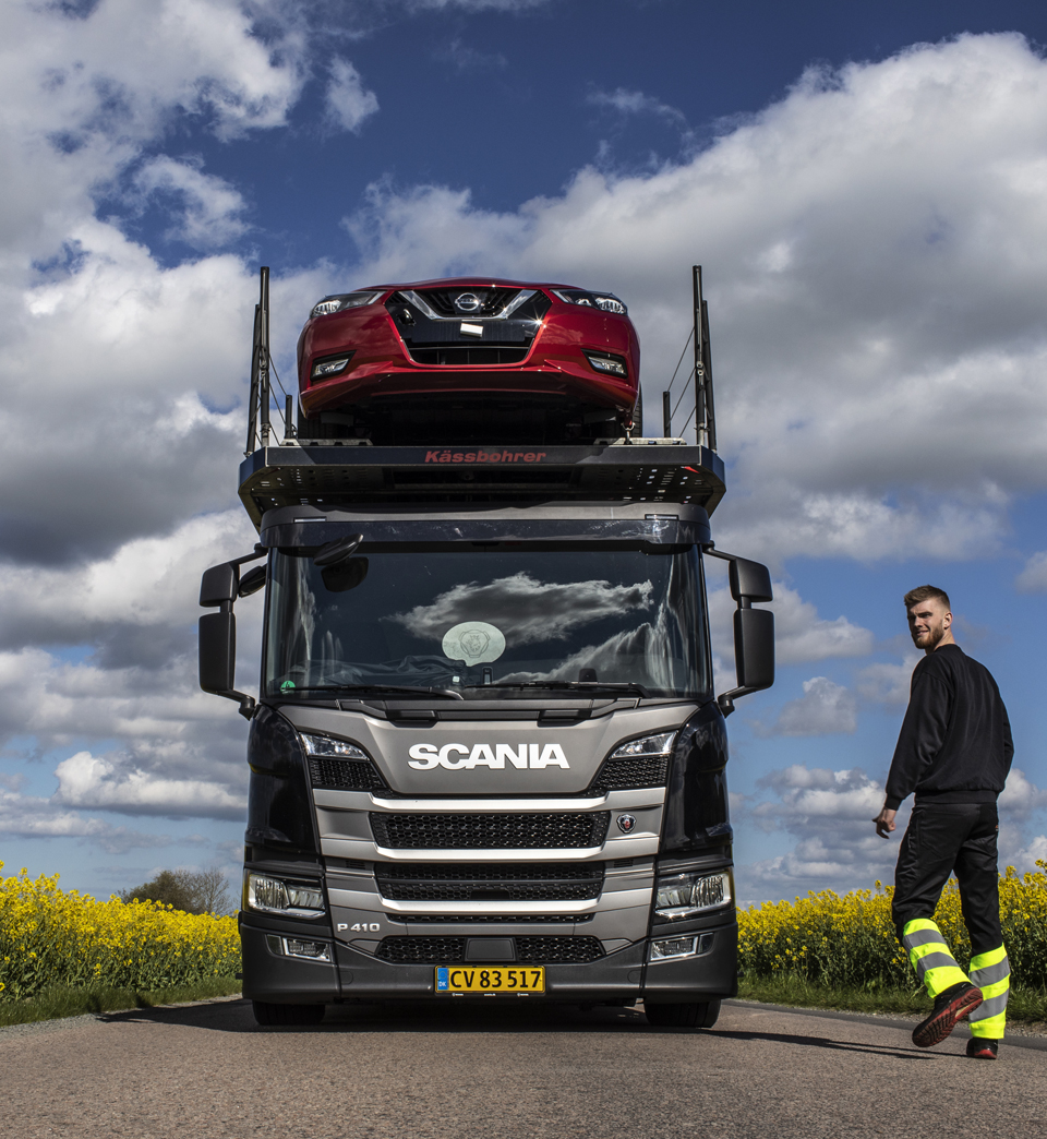 Chaufför tagit en paus på landet, rapsen blommar bredvid vägen.