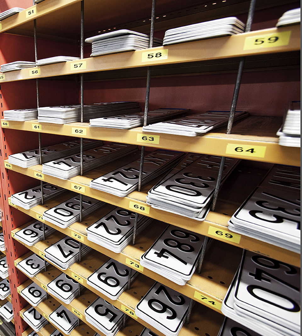 Regskyltar på hylla inför montering.