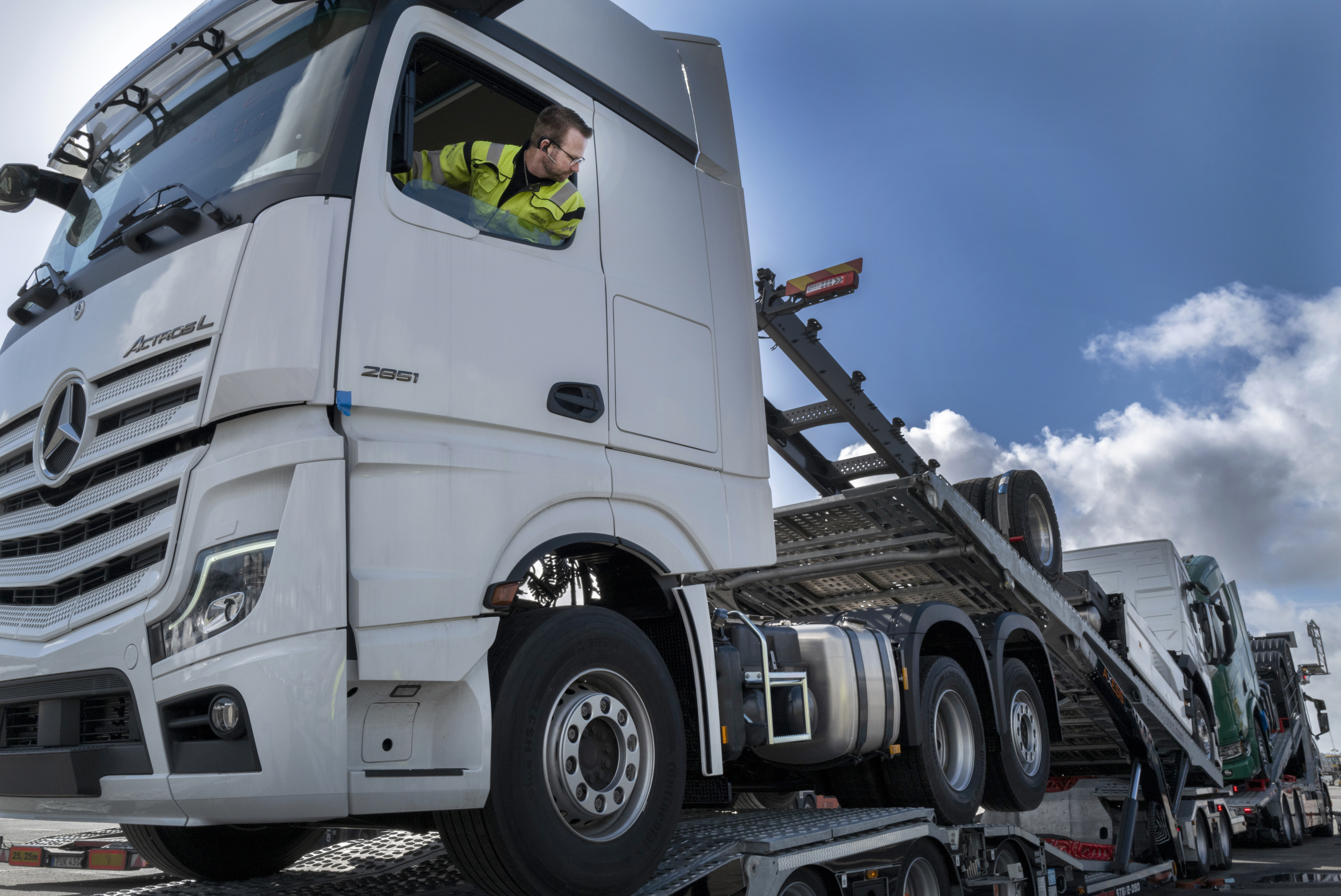 Chaufför backar upp lastbil på biltransport.